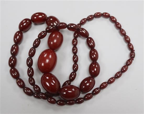 A single strand graduated simulated cherry amber bead necklace, 92cm.